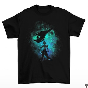 May include: Black t-shirt featuring a silhouette of a character with a sword, set against a teal and blue nebula background. Above the character is a black meteor. The design is a graphic illustration.