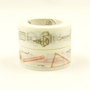 May include: A roll of decorative washi tape with a white background and gold and red illustrations of tools and geometric shapes. The text on the tape reads "BEAKER", "ALCOHOL LAMP", "set wishes", "holiday".