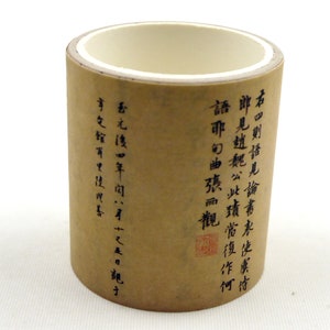 Puede incluir: Un tubo de papel marrón con escritura de caligrafía negra en caracteres chinos. El texto dice "右田則語見論書未使虞古郎見趙魏公此讀當復作何語取り曲張而觀香元後四年市文館有里使四喜才十之五日龍力".