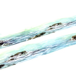 May include: A roll of washi tape with a watercolor design of blue ocean waves crashing against brown rocks.
