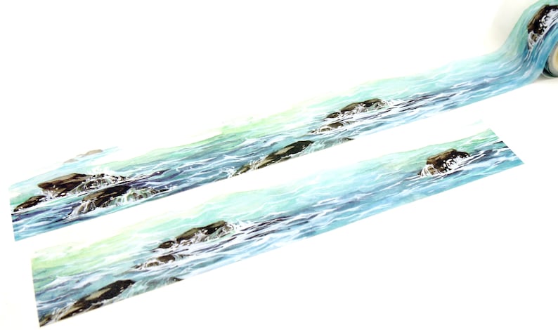 May include: A roll of washi tape with a watercolor design of blue ocean waves crashing against brown rocks.