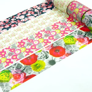 Puede incluir: Un rollo de cinta adhesiva decorativa con cuatro patrones florales distintos. Los diseños incluyen un fondo oscuro con rosas rosadas, un fondo blanco con pequeñas hojas verdes, un estampado floral rosa brillante y grandes flores rojas y grises.
