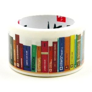 May include: A white washi tape roll featuring a colorful bookshelf design. The tape is decorated with various book spines in shades of blue, red, orange, and green, with text labels on the spines. The interior of the roll has Japanese text.