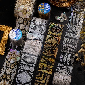 May include: Assortment of decorative washi tapes featuring intricate gold and silver designs. The tapes have a holographic finish and are perfect for adding a touch of elegance to crafts, journals, and other projects.