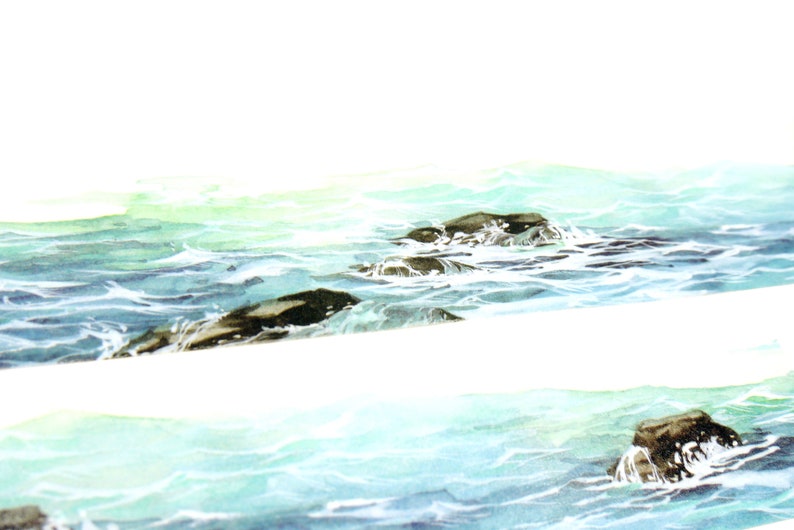 May include: A watercolor painting of a seascape with dark gray rocks partially submerged in the turquoise water. The water is depicted with white foam and ripples, creating a sense of movement.