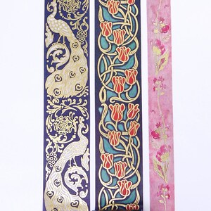 Pu&ograve; includere: Tre rotoli di nastro washi decorativo con accenti dorati. Il primo rotolo presenta un motivo di pavone su uno sfondo blu scuro. Il secondo rotolo presenta un motivo di tulipano su uno sfondo turchese. Il terzo rotolo presenta un motivo floreale su uno sfondo rosa.