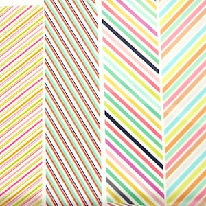 Puede incluir: Cuatro tiras verticales de papel estampado con rayas diagonales en varias combinaciones de colores. Los patrones incluyen líneas finas, líneas punteadas y bandas sólidas en tonos rosa, amarillo, naranja, verde, azul claro y azul marino oscuro.