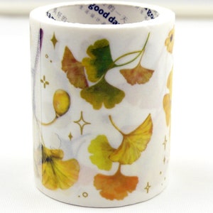May include: Washi tape roll featuring a repeating pattern of yellow and green ginkgo leaves, gold stars, and the text "good day". Ideal for crafts, scrapbooking, and journaling. The tape is white.