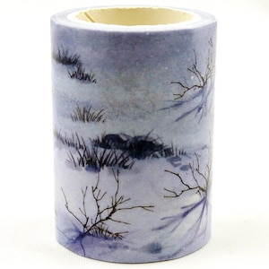 Pode incluir: Um rolo de fita washi com um design de cena de inverno. A fita apresenta um fundo azul claro com neve branca e galhos pretos.