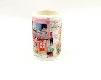 May include: A roll of white washi tape with a colorful illustration of a Japanese street scene. The scene includes a pink building with a sign that says "Sen", a blue sky, and fireworks.