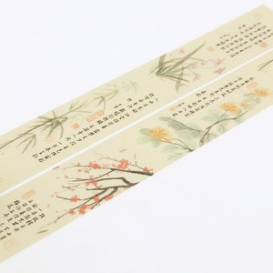 May include: A roll of decorative washi tape with a beige background and a floral design. The tape features delicate illustrations of bamboo, flowers, and Chinese calligraphy. The text on the tape reads: "The wind blows through the bamboo forest, rustling the leaves. The flowers bloom in the spring, filling the air with fragrance."