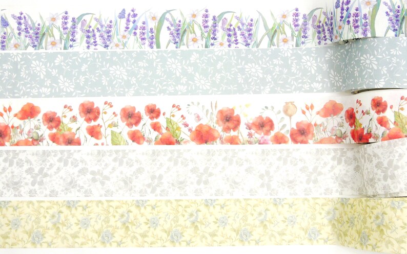 Puede incluir: Cuatro rollos de cinta washi con dise&ntilde;os florales. El rollo superior presenta flores de lavanda y hojas verdes. El segundo rollo tiene un fondo azul claro con un patr&oacute;n floral blanco. El tercer rollo tiene un fondo blanco con flores de amapola rojas y hojas verdes. El rollo inferior tiene un fondo amarillo con un patr&oacute;n floral blanco.