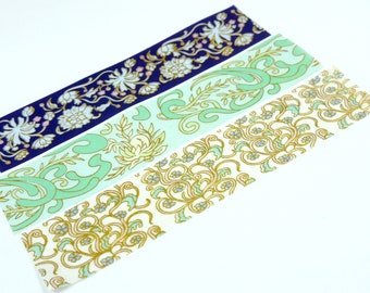 May include: Four decorative washi tapes with floral and swirling patterns. The tapes feature designs in navy blue, mint green, and cream, with gold and pink accents. These tapes are ideal for scrapbooking, journaling, and craft projects.