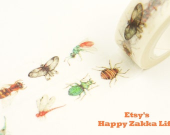 May include: A roll of washi tape with a clear background and colorful insect illustrations. The insects include a butterfly, a dragonfly, a beetle, and a bee. The tape is labeled "Etsy's Happy Zakka Life".