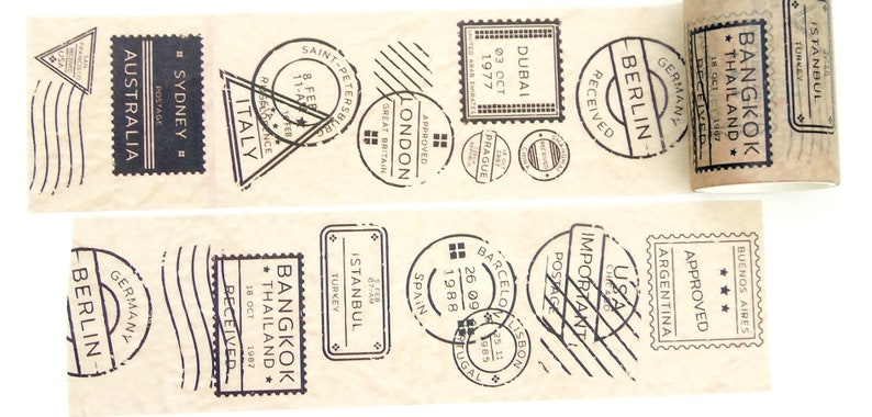 May include: A brown paper tape dispenser with black and white stamps featuring city names and dates. The stamps include "Bangkok, Thailand", "Berlin, Germany", "Istanbul, Turkey", "Dubai", "London", "Saint Petersburg", "Argentina", "USA", "Spain", "Barcelona", "Lisbon", "Italy", "Sydney, Australia".