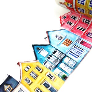 May include: A roll of washi tape featuring a watercolor illustration of colorful European-style houses. The houses are painted in shades of yellow, blue, red, and orange, with white window frames and doors. The tape is on a white background.