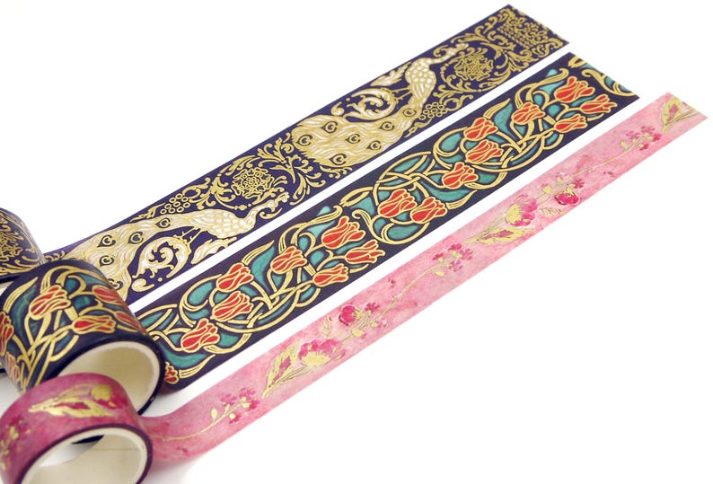 Pu&ograve; includere: Tre rotoli di nastro washi decorativo con dettagli dorati. Il primo rotolo presenta un design di pavone su uno sfondo blu scuro. Il secondo rotolo presenta un design floreale con tulipani rossi su uno sfondo blu scuro. Il terzo rotolo presenta un design floreale con dettagli rosa e dorati su uno sfondo bianco.