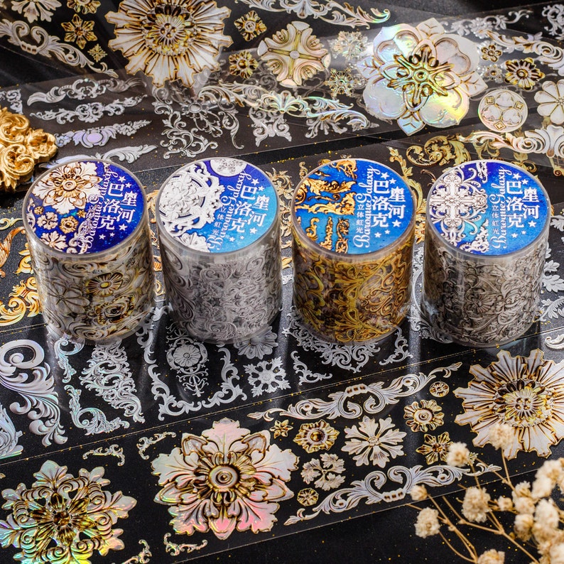 May include: Four rolls of decorative washi tape with gold and silver designs. The tape features intricate patterns of baroque-style swirls and floral motifs. The text on the tape reads "BaGalaxy" and "塵河*巴洛克".