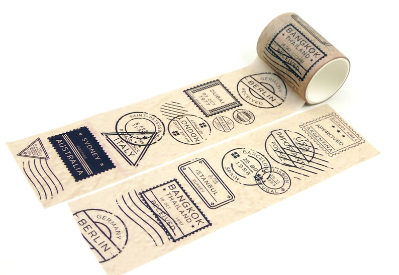 May include: A roll of brown washi tape featuring black ink stamps of various cities and countries, including Bangkok, Thailand, Berlin, Germany, Dubai, and Sydney, Australia. The tape has a vintage, travel-inspired design.