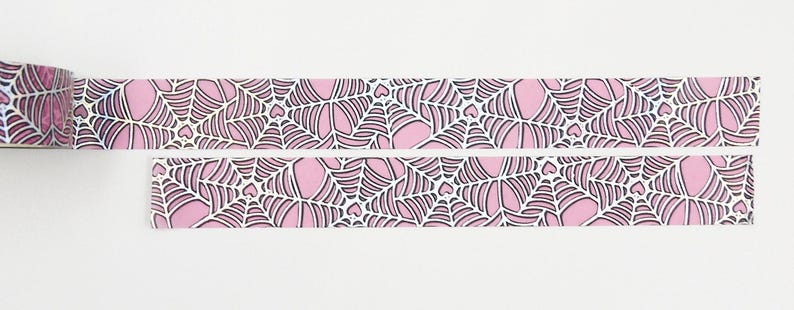 May include: Pink and white washi tape with a black spiderweb pattern and small hearts.