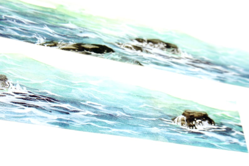 May include: A watercolor painting of a seascape with blue and green water and dark brown rocks. The water is choppy and the rocks are partially submerged.