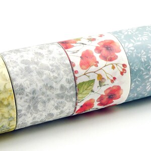 Puede incluir: Un conjunto de seis rollos de cinta washi decorativa con motivos florales. Las cintas son de varios colores, incluyendo verde, amarillo, rojo, azul y blanco. Los motivos incluyen flores, hojas y enredaderas.