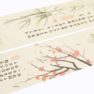 May include: A roll of decorative washi tape with a beige background and a delicate floral design. The tape features a branch of pink blossoms, a bamboo plant, and a yellow flower. The tape also includes text in Japanese characters.