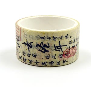 Puede incluir: Un rollo de cinta adhesiva washi decorativa con fondo crema y caligrafía negra. La cinta presenta sellos rojos y texto en formato vertical. Es un suministro de manualidades.