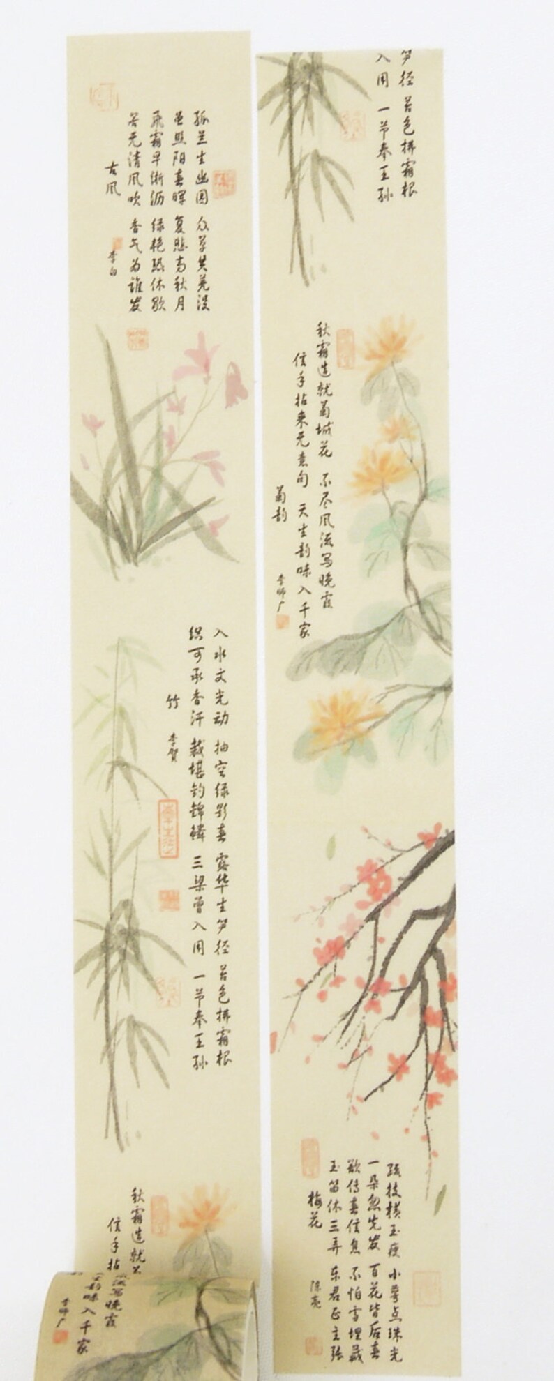 May include: Two strips of decorative washi tape with a light beige background and delicate floral illustrations in shades of pink, yellow, and green. The tape features traditional Japanese calligraphy in black ink. The text reads: "笋经居色拼有权 入用一节春王孙 孤兰士出国众享其美浸 圣阳毒复態去秋月 若无清风吹香气为谁发 古风 秋有生就美城花不尽风流马晓霞 信手拈来无意句 天生扒味入千家 入水文光动抽空绿影喜宾华士多经着色排有权 织可承香汗蒸堪的掉棒 三星層入用一节春王孙 竹李賀 孫技楼玉瘦小学点珠光 一朵忽先发 百花皆版喜 歌仔嘉信息不怕盲埋 玉留休三弄乐君主张 荷花 秋霜造就 健亮 伝子指著晚霞 お味入千家"