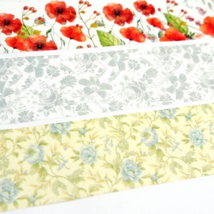 Puede incluir: Tres tiras de tela estampada con dise&ntilde;os florales. La tira superior presenta amapolas rojas sobre un fondo blanco. La tira del medio tiene un patr&oacute;n floral gris sobre un fondo blanco. La tira inferior tiene un patr&oacute;n floral azul claro sobre un fondo amarillo.