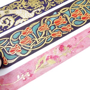 Pu&ograve; includere: Tre rotoli di nastro washi decorativo con dettagli dorati. Il primo rotolo presenta un design di pavone su uno sfondo blu scuro. Il secondo rotolo presenta un design floreale con tulipani rossi su uno sfondo turchese. Il terzo rotolo presenta uno sfondo acquerellato rosa con dettagli floreali dorati.