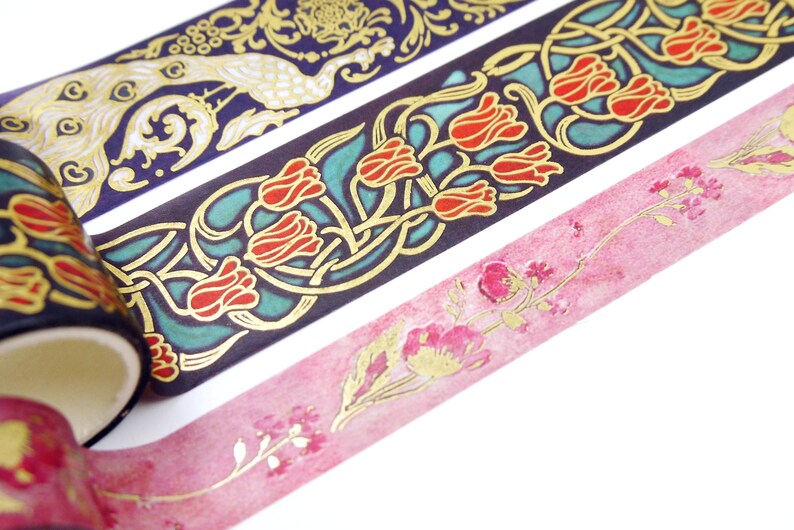 Pu&ograve; includere: Tre rotoli di nastro washi decorativo con dettagli dorati. Il primo rotolo presenta un design di pavone su uno sfondo blu scuro. Il secondo rotolo presenta un design floreale con tulipani rossi su uno sfondo turchese. Il terzo rotolo presenta uno sfondo acquerellato rosa con dettagli floreali dorati.
