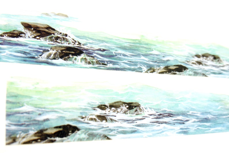 May include: A watercolor painting of a seascape with dark brown rocks and white foamy waves. The water is a light blue and green color.