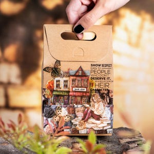 Peut inclure: Une bo&icirc;te cadeau en papier brun avec une poign&eacute;e d&eacute;coup&eacute;e, pr&eacute;sentant une illustration d&eacute;taill&eacute;e d'une librairie avec des papillons et une citation : "SHOW RESPECT EVEN TO PEOPLE WHO DON'T DESERVE IT..."