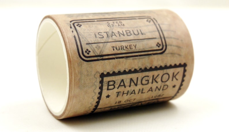 May include: A roll of brown washi tape with black stamps that say "ISTANBUL TURKEY" and "BANGKOK THAILAND".
