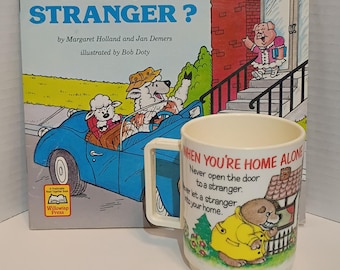 vintage children's book titled "How Do You Know Who's a Stranger?" 1987 & 1985 Deka Plastics child's mug featuring cartoon stranger danger