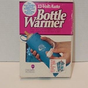 May include: A rectangular product box for a 12-Volt/Auto Bottle Warmer by Children on the Go. The box is white with a large magenta panel featuring text that reads: Fits bent bottles, standard bottles and even disposable nursers, 12-Volt/Auto Bottle Warmer, Plugs into cigarette lighter to warm baby's bottle in the car, boat or RV!, and Wraps snugly around all bottles with velcro tapes!