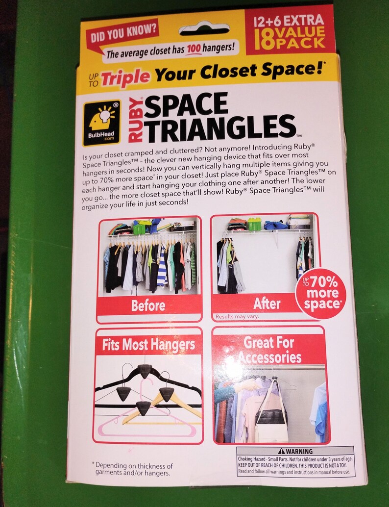 Op de afbeelding: Een gele en rode doos voor Ruby Space Triangles, een hulpmiddel voor kastorganisatie. De doos bevat tekst en afbeeldingen die laten zien hoe het product de kastruimte vergroot. Het product beweert de kastruimte te verdrievoudigen.