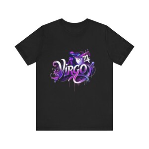 Peut inclure: T-shirt noir avec un graphisme coloré du mot "Virgo" dans une police stylisée, accompagné du symbole astrologique de la Vierge. Le design comprend des nuances de violet, de bleu et de blanc. Le t-shirt est en tissu doux.