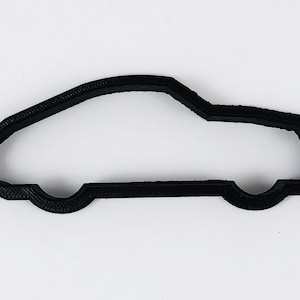 Pode incluir: Cortador de biscoitos de plástico preto em forma de carro.