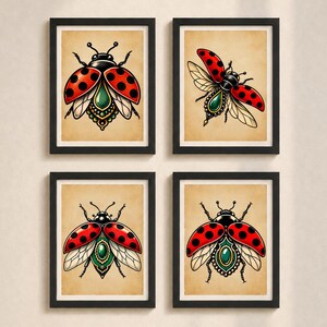 May include: Four framed wall art prints featuring stylised ladybird illustrations. Each print displays a red ladybird with black spots, intricate green and gold ornamental details on the body, and translucent wings, set against a beige background.
