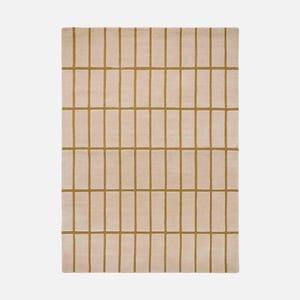 May include: A rectangular rug with a grid pattern. The rug has a light beige background with a series of vertical and horizontal lines in a mustard yellow color, creating a geometric design. The rug is made of a soft, plush material.