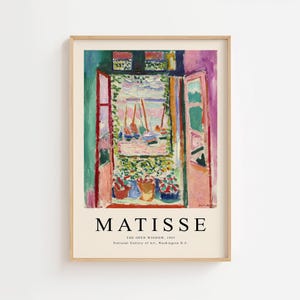 May include: A framed print of Matisse's "The Open Window, 1905." The artwork depicts an open window overlooking a harbor with sailboats. The color palette includes pink, green, blue, and red, with the word "MATISSE" at the bottom.