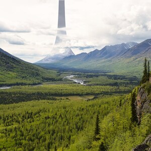 以下が含まれることがあります： 緑豊かな谷と川が流れ、山々に囲まれた風景。遠くには、雲に隠れた高い暗い構造物が見える。前景には、岩だらけの崖と木々が写っており、ドラマチックな風景を作り出している。