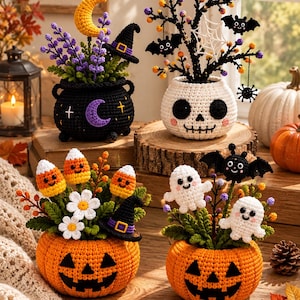 May include: Four crocheted Halloween decorations featuring a black cauldron with a moon and lavender, a white skull pot with a bat tree, an orange pumpkin with candy corn and daisies, and an orange pumpkin with two white ghosts and a black bat.