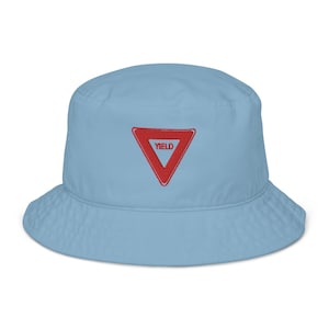 May include: A light blue bucket hat with a red yield sign embroidered on the front.