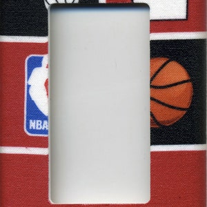 May include: A red, white, and black light switch cover with the Houston Rockets logo, the team's name, and a basketball. The switch cover also features an NBA logo and a basketball jersey.