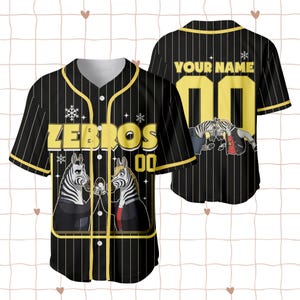 Puede incluir: Camiseta de b&eacute;isbol negra con rayas finas y detalles amarillos. El frente muestra "ZEBROS" en amarillo, el n&uacute;mero "00" y un dise&ntilde;o de cebra de dibujos animados. La parte trasera tiene "YOUR NAME" y "00" en amarillo, con un gr&aacute;fico de cebra.