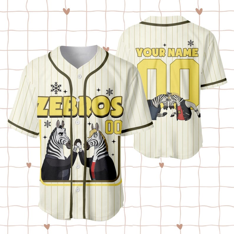 Puede incluir: Camiseta de b&eacute;isbol color crema con rayas verticales y cierre de botones. La camiseta presenta la palabra "ZEBROS" en letras amarillas, junto con un gr&aacute;fico de dos cebras. Tambi&eacute;n se muestra el n&uacute;mero "00".