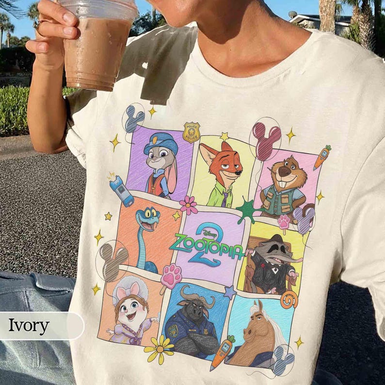 Puede incluir: Camiseta de color marfil con un gr&aacute;fico colorido de personajes de la pel&iacute;cula de Disney Zootopia. El dise&ntilde;o incluye a Judy Hopps, Nick Wilde y otros personajes en un patr&oacute;n de cuadr&iacute;cula. La camiseta est&aacute; hecha de un material suave.
